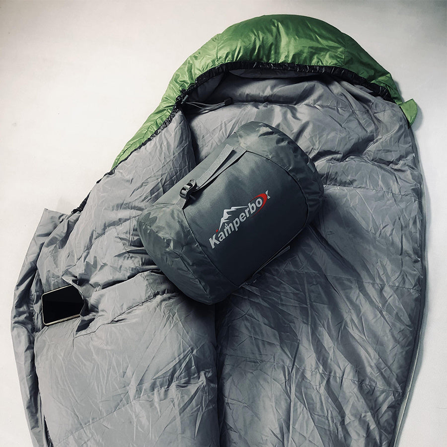 Gray sleeping bag with green hood and Kamperbo logo on a white background